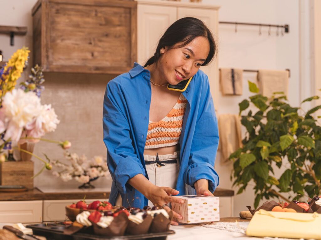 Small business owner taking a customer call while packing an order