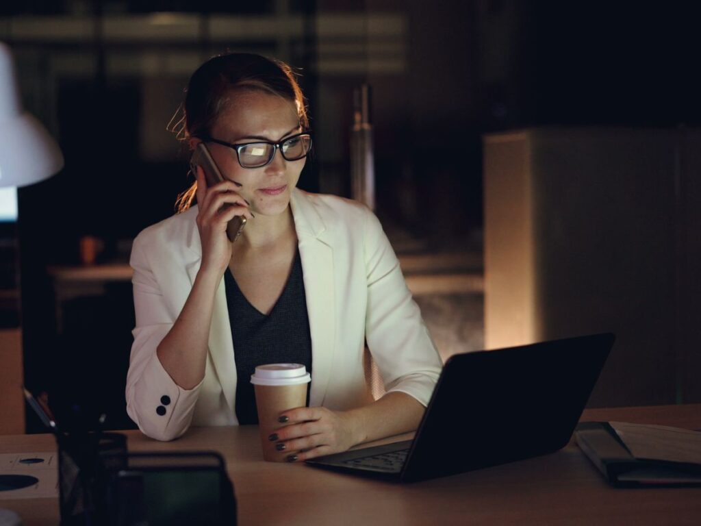 Business owner on the phone working late in the office in the evening